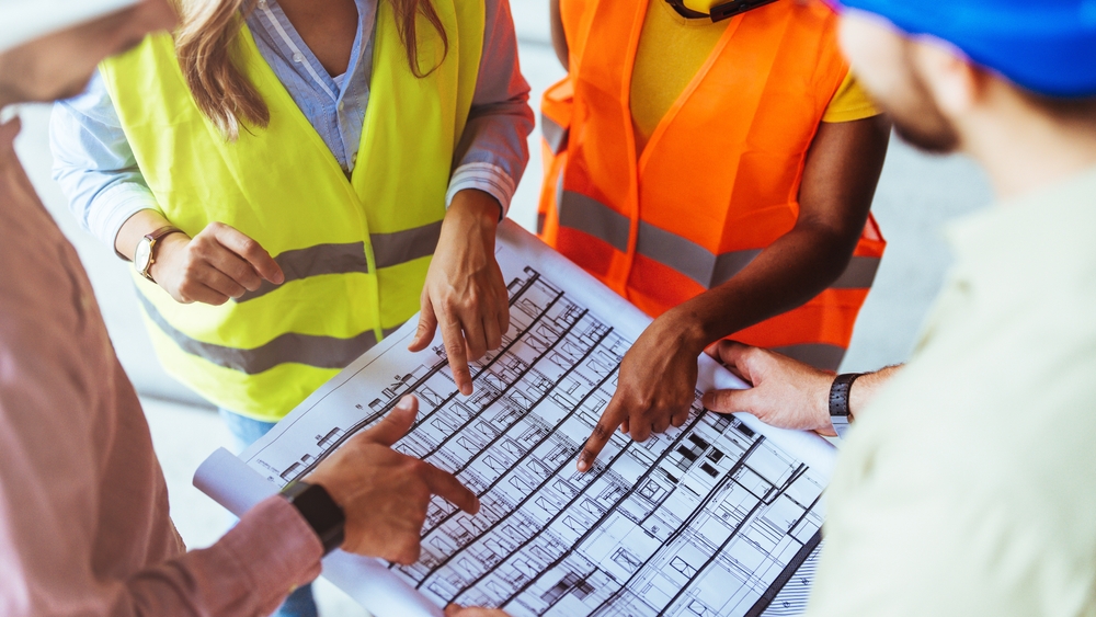 A,Group,Of,Construction,Workers,In,Safety,Vests,Engage,In